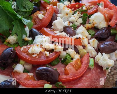A freshly baked homemade gourmet pizza on a rustic wooden board, ready to be served. Stock Photo