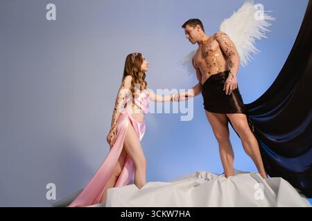 Couple in fantasy attire posing together on a creative stage setting Stock Photo
