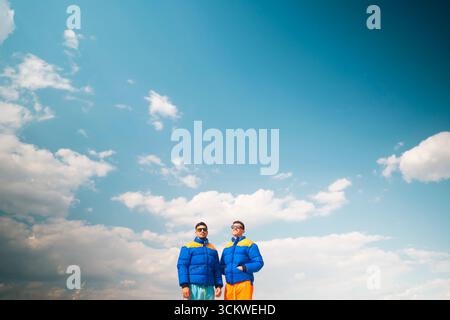 Two men in colorful jackets under blue sky Stock Photo