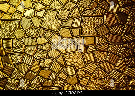 Golden antique background with polygonal texture and geometric pattern on a metal plate, close up Stock Photo