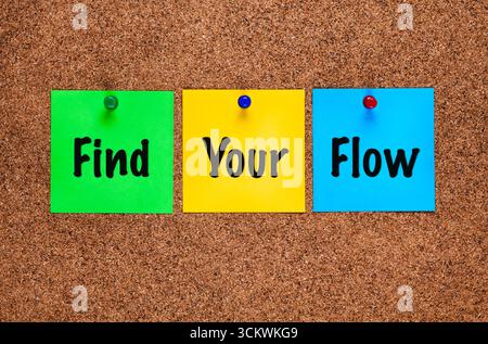 Three colored paper notes with words Find Your Flow on a corkboard. Close-up Stock Photo