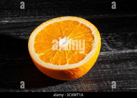 sliced oranges on black wood background Stock Photo
