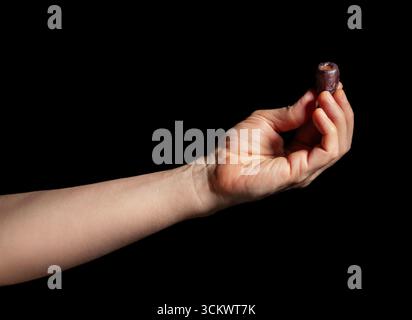 dates fruit in hand on black background Stock Photo