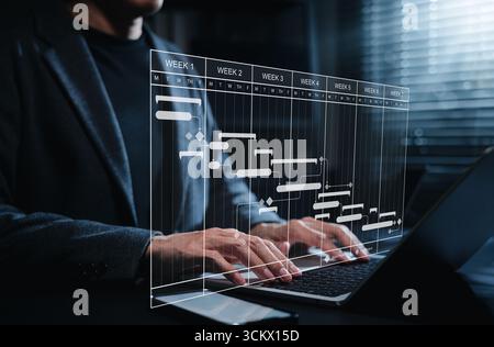 Project timeline and Gantt chart planning concept. Businessman working on laptop, managing tasks and deadlines through digital scheduling software Stock Photo