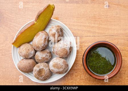 Top view of traditional Canarian wrinkled potatoes served with baked sweet potato and green mojo sauce. Typical food of the Canary Islands, Spanish cu Stock Photo