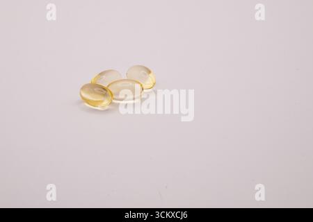 Close-up photo of vitamin E tablets on a white background, representing health, nutrition, wellness, supplements, and healthcare concepts. Stock Photo
