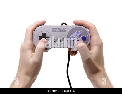 1991 Hands holding controller for Super Nintendo Entertainment System (SNES or Super NES) video game console Stock Photo