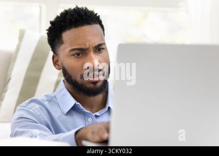 Closeup portrait young man working on notebook from home office Stock Photo