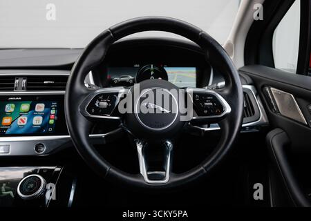 Derby, UK - Sep 13 2025: Jaguar steering wheel, highlighting the signature Jaguar logo, integrated multifunction control buttons Stock Photo