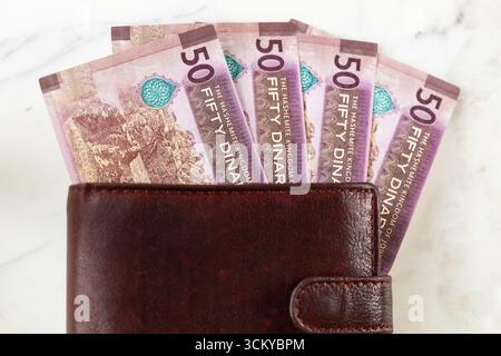 Jordan money. Jordanian 50 dinar bills sticking out of a wallet. Currency JOD. Business and financial concept. close up Stock Photo