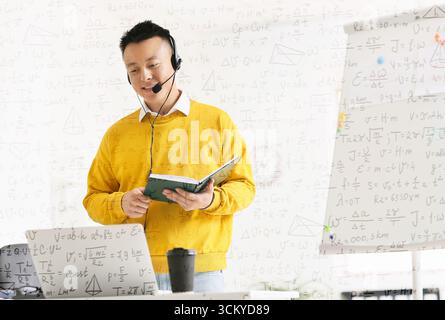 Asian teacher conducting lesson online Stock Photo