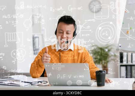 Asian teacher conducting lesson online Stock Photo