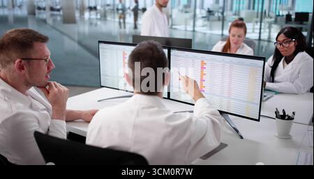 Hospital Doctors Review Medical Billing Codes Online For Diverse Team. Woman And Man Stock Photo