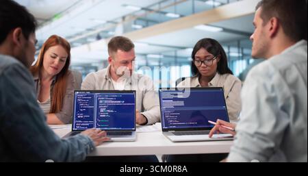 Young African American Software Engineer Typing Code On Laptop Screen. Stock Photo