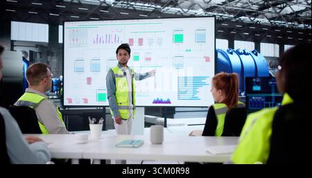 Engineer Leading Diverse Team In Presentation For Training Session In AI Technology. Stock Photo