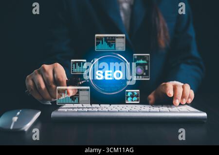 Women using magnifying glasses, computers focus on SEO analysis, search engine optimization to improve website ranking, increase internet traffic, pro Stock Photo