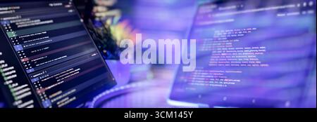 Modern coding setup with two monitors displaying Python scripts, showcasing software development, scripting, and a high-tech workflow. Stock Photo