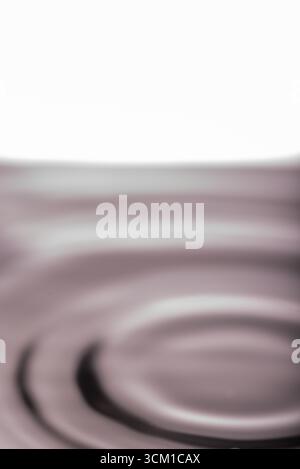 254.Macro Shot of Water Ripples and Waves254.This vertical abstract image captures a close-up of subtle circular ripples on a calm liquid surface. Sof Stock Photo