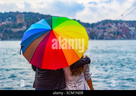 Couple with rainbow umbrella overlooking bosphorus Stock Photo