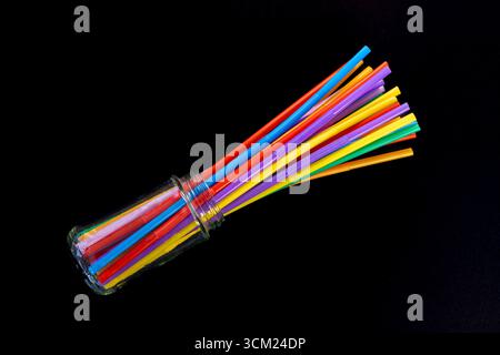 Colorful Drinking Straws Fanned Colorful Drinking Straws Fanned Out from Glass Jar on Black Background. Stock Photo