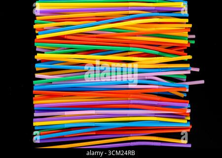 Horizontal Stack of Colorful Bendable Drinking Straws on Black Background Stock Photo