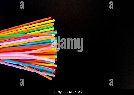 Radial Burst of Colorful Plastic Drinking Straws on Black Background Stock Photo