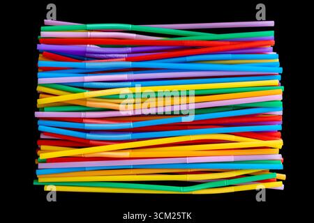 Neatly Stacked Colorful Plastic Drinking Straws on Black Background Stock Photo