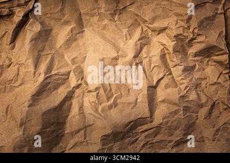 Crumpled brown paper. Rumpled brown cardboard paper texture. Wrinkled brown paper sheet. Stock Photo