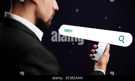 Man holding a phone with a search bar against a dark background, exploring the digital world and online resources Stock Photo