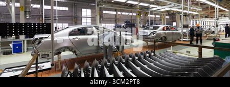 Engineer looks into the cab of the car on the production line. Automotive production line. long format. Wide frame Stock Photo