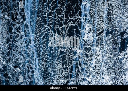 Frozen water with various ice patterns, cracks and drips. Stock Photo