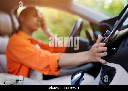 Black woman in car, stressed and touching forehead while adjusting air vent Stock Photo