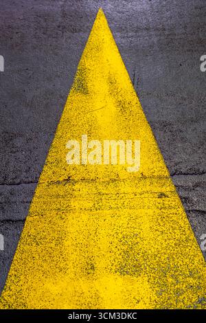 London UK, September 14 2025,  Yellow Painted Arrow On A Tarmac Road Stock Photo