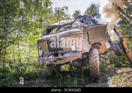 Smoke is coming from a damaged military truck, a drone attack, or Stock Photo