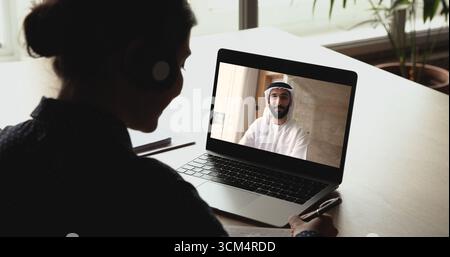Arabian man leading on-line talk to Indian female colleague Stock Photo