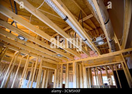 Workers are installing ductwork, completing framing in residential construction project. Stock Photo