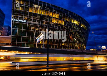 Illuminated Tram Station and a Modern Office Building in Circle in Zurich Airport at Dusk in Kloten, Zurich, Zurich Canton, Switzerland. Stock Photo