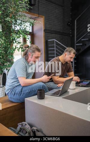 Two It Software engineers working on project and programming in coffee shop. Business people concept. Stock Photo