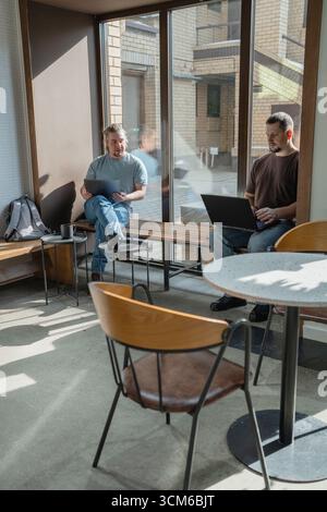 Two knowledgeable professionals collaborating effectively together in a modern workspace setting Stock Photo
