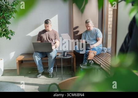 Two It Software engineers working on project and programming in coffee shop. Business people concept. Stock Photo