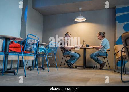 Two It Software engineers working on project and programming in coffee shop. Business people concept. Stock Photo