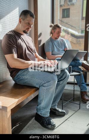 Casual Meeting in Modern Cafe. Team of programmers writing digital code in the metaverse and working together Stock Photo