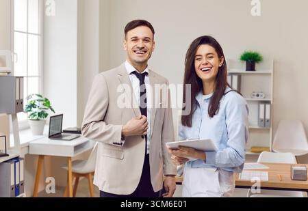 Portrait Of Happy Colleagues Smiling At The Camera In The Office Stock Photo