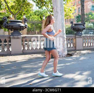Woman in activewear walking confidently. Urban fitness activity Stock Photo