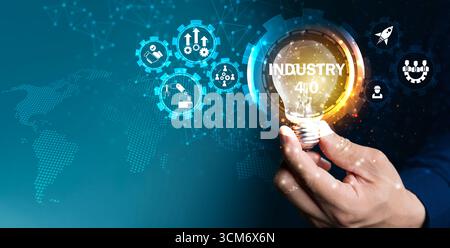 Hand holding glowing light bulb with Industry 4.0 icons and digital world map background. Concept of smart technology, automation, innovation, artific Stock Photo