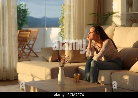 Relaxed woman resting with closed eyes sitting on a couch at home Stock Photo