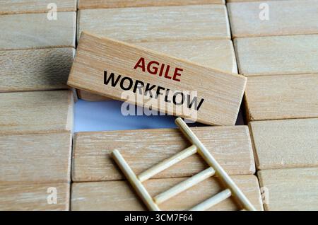 A wooden block marked AGILE WORKFLOW on steps reflecting adaptability, innovation, iteration, progress and efficiency Stock Photo