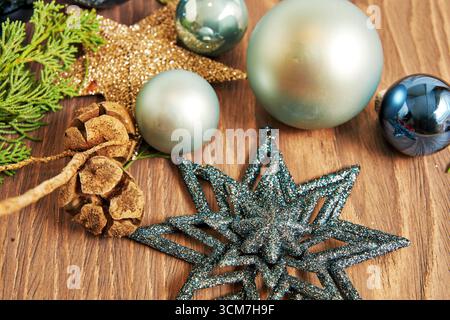 A festive arrangement of Christmas ornaments, pine cones, and greenery on a wooden surface creates a warm and inviting holiday atmosphere Stock Photo