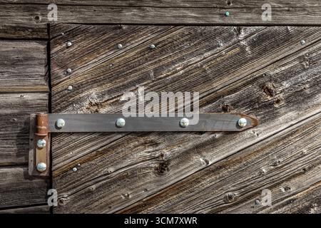 Old wooden door with an old iron hinge Stock Photo