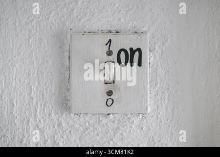 Old vintage rustic light switch on wall with numbers 1 for on and 0 for off, symbolizing control, choice, decision, power, and vintage industrial heri Stock Photo